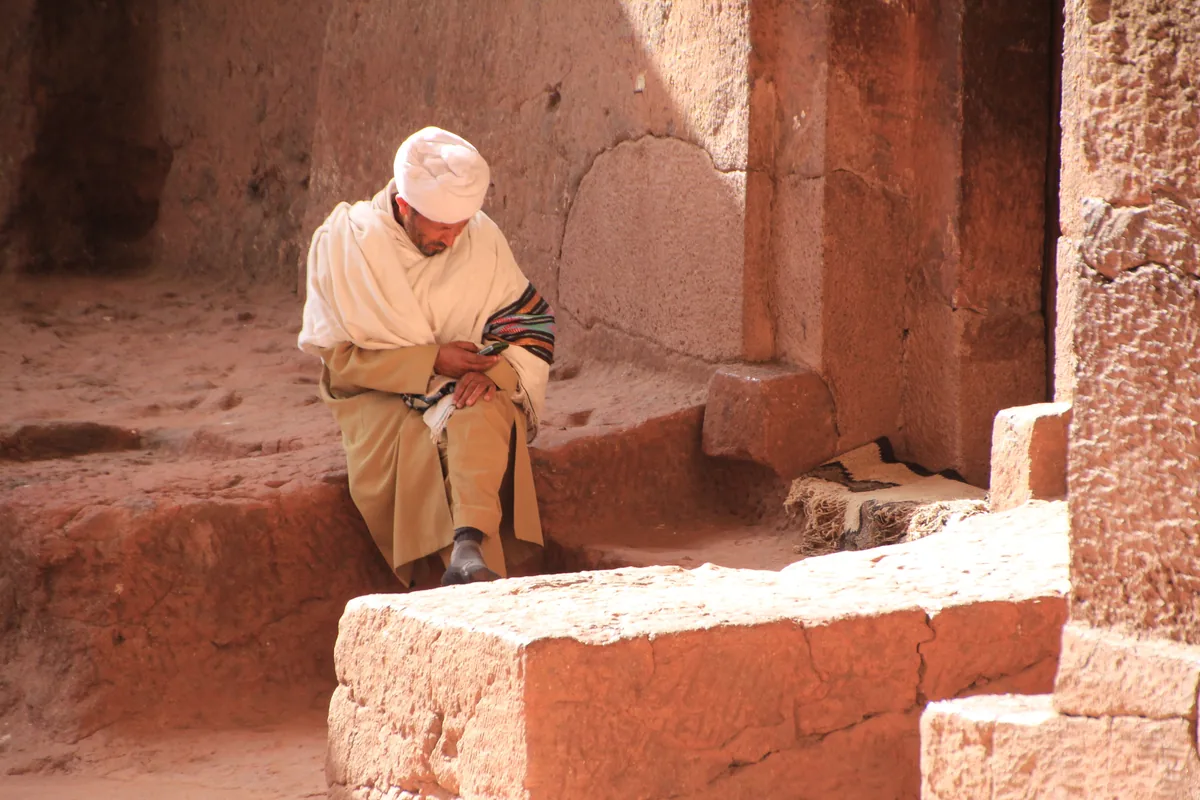Homme en tenue traditionnelle dans une église rupestre de Lalibela, Éthiopie
