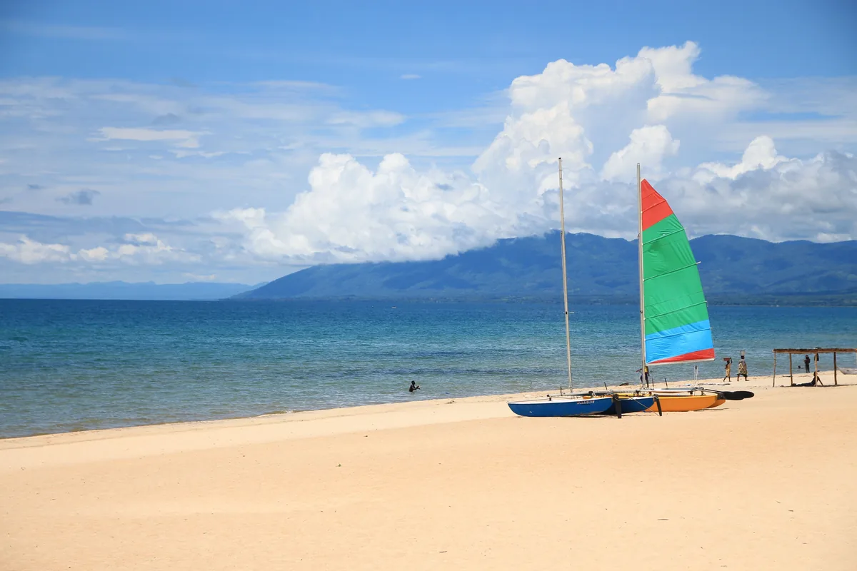 Voiliers de pêcheurs sur une plage du lac Malawi, montagnes en arrière-plan
